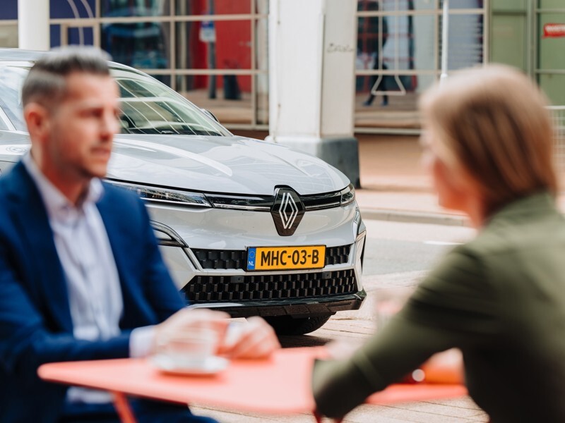 Gesprek over mobiliteit met MHC Mobility-auto op de achtergrond